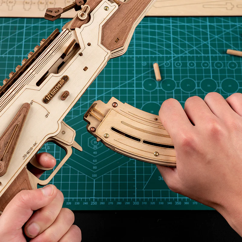 Wooden model of an AK47 assault rifle toy gun by Lumigic, featuring intricate 3D puzzle design and detailed craftsmanship.